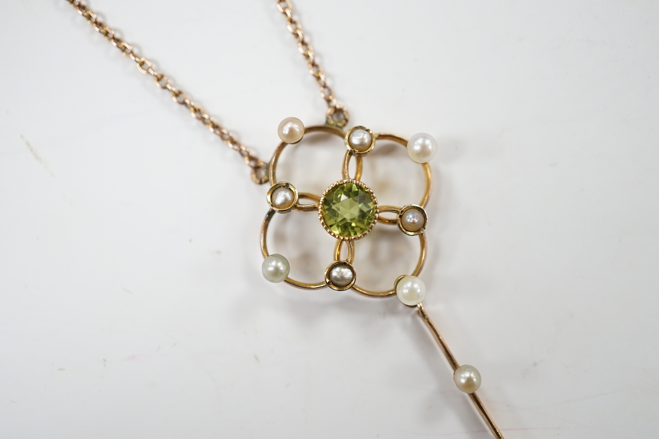An Edwardian 9ct, peridot and seed pearl set drop pendant necklace, 49cm, gross weight 3.5 grams.